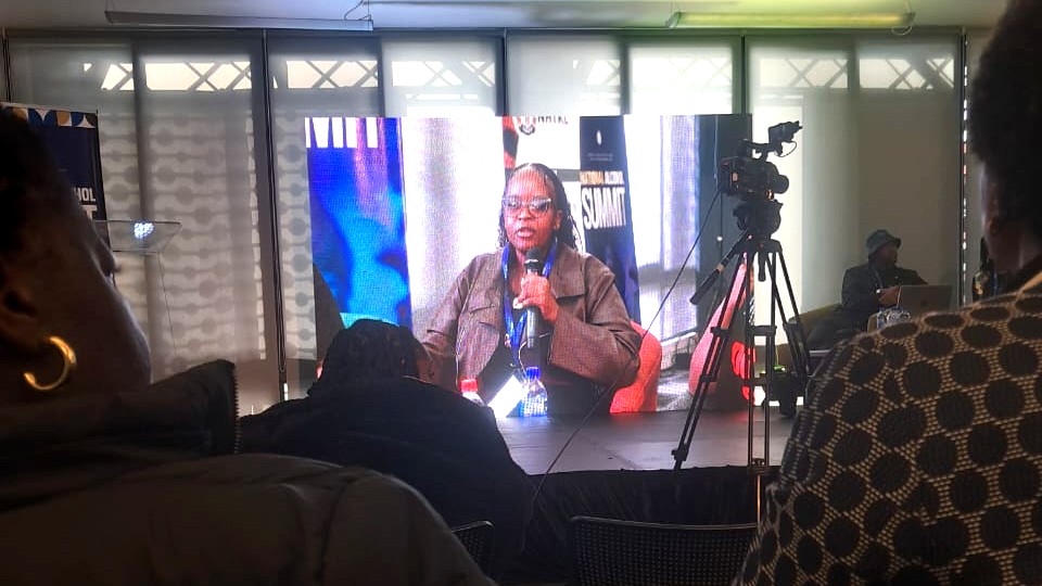 Charity Monareng speaking on screen at the National Alcohol Summit